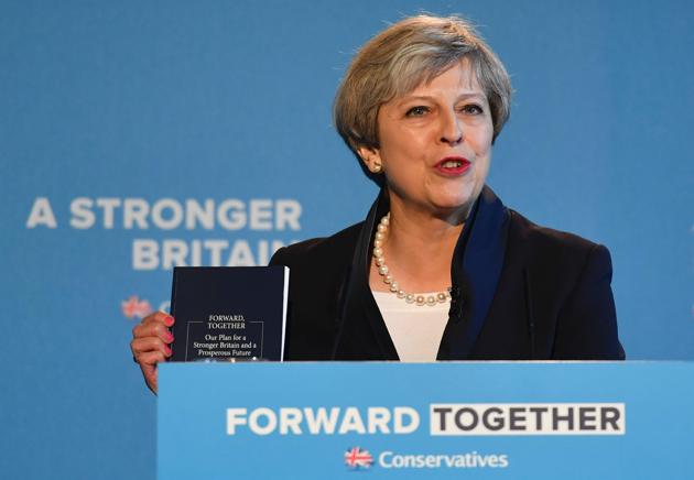 Britain's Prime Minister Theresa May holds up the Conservative Party general election manifesto as she speaks at the launch event in Halifax in northern England on Thursday. (AFP) Britain's Prime Minister Theresa May holds up the Conservative Party general election manifesto as she speaks at the launch event in Halifax in northern England on Thursday. (AFP)