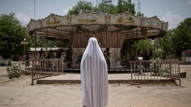 A girl watches other children playing on a merry-go-round in an abandoned amusement park in Maiduguri, Nigeria, on April 27, 2017. In Maiduguri, where the population has doubled to more than two million as a result of Boko Haram insurgency, thousands of children are homeless. (AFP) A girl watches other children playing on a merry-go-round in an abandoned amusement park in Maiduguri, Nigeria, on April 27, 2017. In Maiduguri, where the population has doubled to more than two million as a result of Boko Haram insurgency, thousands of children are homeless. (AFP)