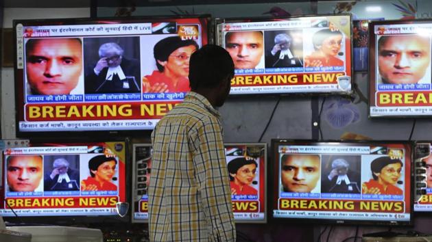A boy watches as television channels that show news about International Court of Justice hearing the case of former Indian naval officer Kulbhushan Jadhav.(AP Photo)