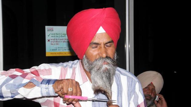 Bahona village sarpanch Harbhajan Singh cutting his beard outside the DC office in Moga on Friday, May 19. (HT Photo) Bahona village sarpanch Harbhajan Singh cutting his beard outside the DC office in Moga on Friday, May 19. (HT Photo)