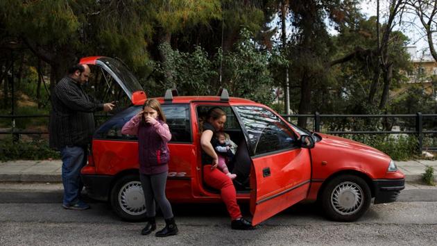 The Argyros family get into their car, which was donated, after receiving goods from an NGO for big families in Athens.Five years since abandoning their home in Leros for Athens, they are trapped in a cycle of unemployment and debt. (Alkis Konstantinidis/REUTERS ) The Argyros family get into their car, which was donated, after receiving goods from an NGO for big families in Athens.Five years since abandoning their home in Leros for Athens, they are trapped in a cycle of unemployment and debt. (Alkis Konstantinidis/REUTERS )