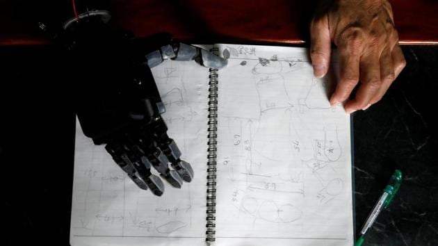 An Engineer who built his own prosthetic arm using 3D printing technology, looks at his notes which shows the condition of eight-year-old girl, who lost her hand, in Taiwan. (Tyrone Siu /REUTERS)