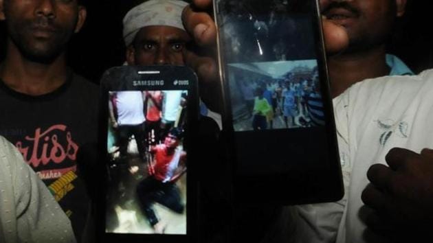 In the photo displayed on the phone, Mohammed Naeem is pleading to a group of villagers as blood trickles down from his head.(Parwaz Khan/HT Photo)