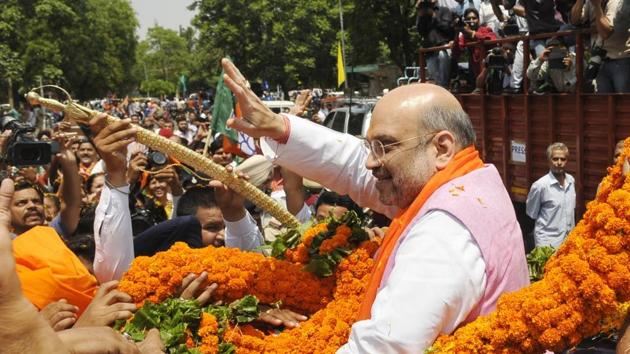 Amit Shah greets his supporters during road show at sector 47 Chandigarh on Saturday. (Karun Sharma/HT Photo)