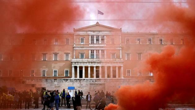 The parliament building is seen through flare smoke during a demonstration of uniformed officers marking a 24-hour general strike against the latest round of austerity in Athens, Greece. (Alkis Konstantinidis /REUTERS)