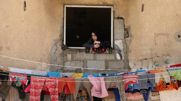 A woman looks out of a house window as she watches the funeral of Palestinian fisherman Mohammed Baker in Gaza City. (Mohammed Salem/REUTERS)
