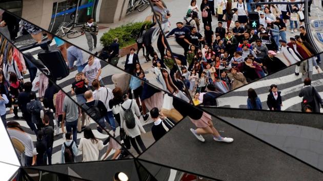 People are reflected in mirrors as they walk in a busy shopping district in Tokyo, Japan. (Toru Hanai /REUTERS)