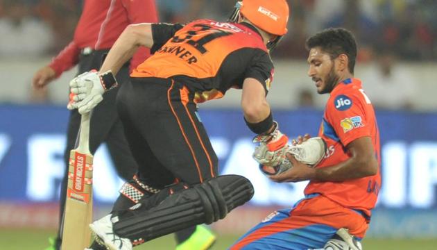 Sunrisers Hyderabad captain David Warner hands a shoe to Gujarat Lions bowler Basil Thampi as he runs between the wickets during a 2017 Indian Premier League (IPL) match.(AFP)