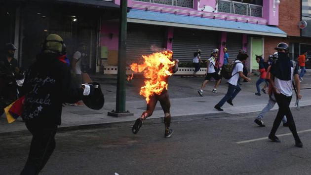A man who was set on fire by people accusing him of stealing during a rally against Venezuela's President Nicolas Maduro runs amidst opposition supporters in Caracas, Venezuela. (Marco Bello / Reuters)
