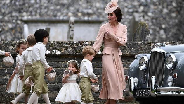 Britain's Catherine, Duchess of Cambridge (R) beckons the bridesmaids and pageboys, including Britain's prince George (2R) and Britain's princess Charlotte (3R) towards a waiting car . (Justin TALLIS / AFP) 