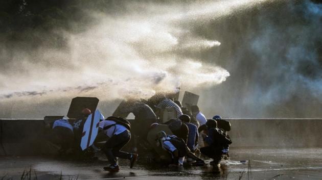 Venezuelan opposition activists clash with the riot police during a rally against the government of President Nicolas Maduro, in Caracas. Venezuelan opposition leader Henrique Capriles said Thursday authorities confiscated his passport and prevented him from travelling to New York to discuss his country's deadly political crisis with United Nations officials. On Monday Venezuelans launched a seventh week of anti-government demonstrations by blocking roads, vowing not to budge all day in protest at a deadly political and economic crisis. (FEDERICO PARRA / AFP)