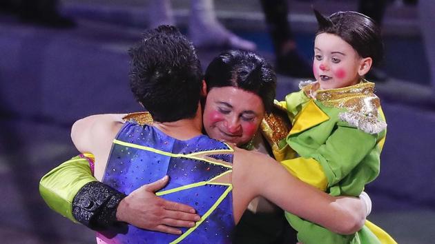 Davis Vassallo, center, hugs a member of the trapeze troupe as he holds his daughter Adriana after the final show. (Julie Jacobson / AP)
