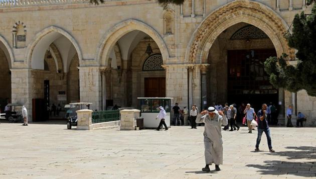 AFTER: Palestinians walk in front of the Dome of the Rock on the compound known to Muslims as Noble Sanctuary and to Jews as Temple Mount. (Ammar Awad / REUTERS)