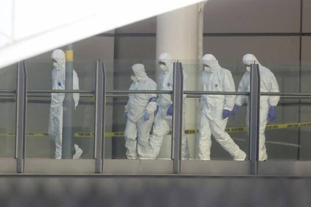 Police forensic investigators walk along a bridge linking Victoria Station with the Manchester Arena . (AP Photo)