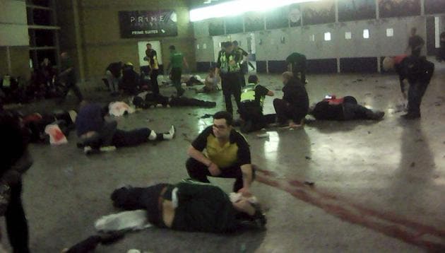 Helpers attend to injured people inside the Manchester Arena, Manchester, Britain, after a blast Monday, May 22, 2017. An apparent suicide bomber attacked an Ariana Grande concert as it ended Monday night, killing over a dozen of people among a panicked crowd of young concertgoers. (AP Photo)