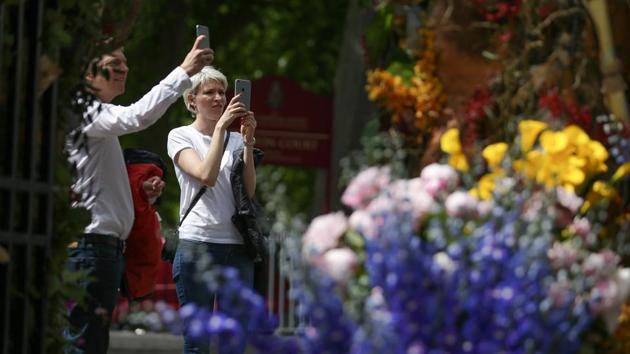 Pedestrians take pictures of a floral gate . (Daniel Leal-Olivas/ AFP) 