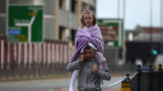 A man carries a young girl on his shoulders near Victoria station in Manchester, northwest England on May 23, 2017. Twenty two people have been killed and dozens injured in Britain's deadliest terror attack in over a decade after a suspected suicide bomber targeted fans leaving a concert of US singer Ariana Grande in Manchester. (AFP) A man carries a young girl on his shoulders near Victoria station in Manchester, northwest England on May 23, 2017. Twenty two people have been killed and dozens injured in Britain's deadliest terror attack in over a decade after a suspected suicide bomber targeted fans leaving a concert of US singer Ariana Grande in Manchester. (AFP)
