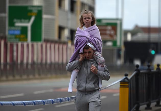 A man carries a young girl on his shoulders near Victoria Station. The blast took place around 10.30pm (3.00 am India time on Saturday) at the foyer of the Manchester Arena, where the concert was attended by thousands, mostly teenagers and children. (Oli SCARFF / AFP Photo)