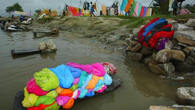 Piles of clothes lie on the banks of the Gomti River waiting to be washed, as washermen work nearby in Lucknow. Dhobi ghats still popular inspite of modern technology and the use of washing machines. (AP)