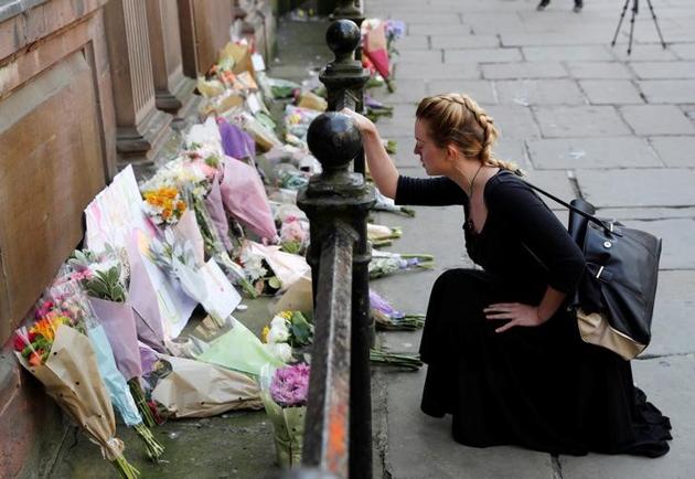 A woman lays flowers for the victims of the Manchester Arena attack, in central Manchester, Britain May 23, 2017. (Darren Staples/REUTERS)