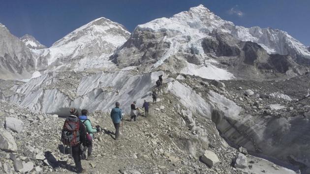 Trekkers pass through a glacier at the Mount Everest base camp. Thousands of tourists visit the base camp every year resulting in overcrowding and environmental degradation. (AP)