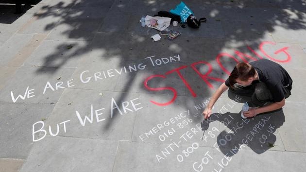 A man writes a message on the pavement in central Manchester, Britain on Tuesday.(REUTERS)