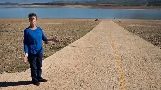 Lisa Wheeler, secretary of the Theewaterskloof Sports Club, shows where the high water mark of the dam is, which has less than 20% of it's water capacity, near Villiersdorp, about 108Km from Cape Town. (Rodger Bosch / AFP) Lisa Wheeler, secretary of the Theewaterskloof Sports Club, shows where the high water mark of the dam is, which has less than 20% of it's water capacity, near Villiersdorp, about 108Km from Cape Town. (Rodger Bosch / AFP)