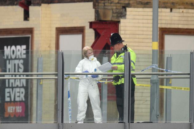 A forensic officer (L) collects evidence on a walkway between Victoria station and Manchester Arena following a deadly terror attack . (Oli SCARFF / AFP Photo)