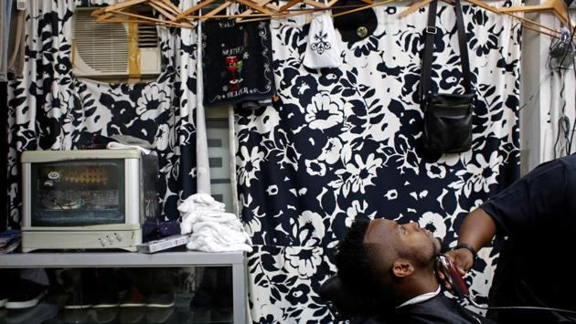 Habib Mamadou Bah, 21, from Guinea, is shaved at a barber shop. (Bobby Yip/REUTERS) Habib Mamadou Bah, 21, from Guinea, is shaved at a barber shop. (Bobby Yip/REUTERS)