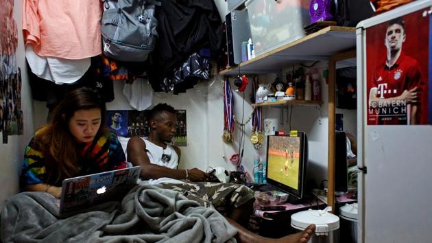 Habib Mamadou Bah, 21, and his girlfriend Karin lie on a bed at their home, a five-square-metre sub-divided unit. Eric Lee, a local player says that they don’t mind their work and their personality. They just talk about football. (Bobby Yip/REUTERS) Habib Mamadou Bah, 21, and his girlfriend Karin lie on a bed at their home, a five-square-metre sub-divided unit. Eric Lee, a local player says that they don’t mind their work and their personality. They just talk about football. (Bobby Yip/REUTERS)