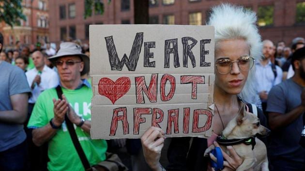 A woman holds a placard as she takes part in a vigil in central Manchester. (Reuters Photo) A woman holds a placard as she takes part in a vigil in central Manchester. (Reuters Photo)