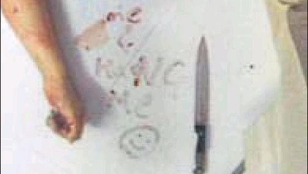 The note signed with a smiley next to the victim’s body.