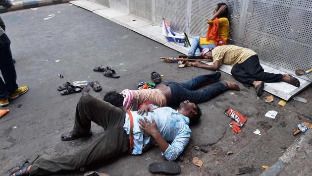 BJP activists lying on the road after being cane charged by the police. (PTI) 