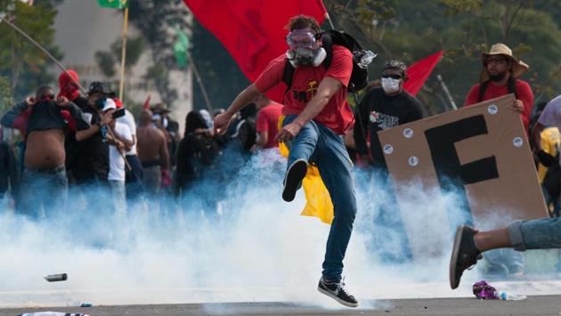 Masked protesters fired powerful fireworks at police, set ablaze furniture in the Agriculture Ministry, and sprayed anti-Temer graffiti on government buildings. (Andressa Anholete / AFP) Masked protesters fired powerful fireworks at police, set ablaze furniture in the Agriculture Ministry, and sprayed anti-Temer graffiti on government buildings. (Andressa Anholete / AFP)