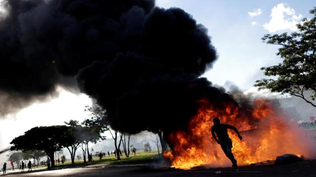 A demonstrator runs near a burning barricade during a protest against President Michel Temer, in Brasilia, Brazil. Protesters demanding the resignation of Brazilian President Michel Temer staged running battles with police and set fire to a ministry building in Brasilia on Wednesday, prompting the scandal-hit leader to order the army onto the streets. (Ueslei Marcelino / Reuters) A demonstrator runs near a burning barricade during a protest against President Michel Temer, in Brasilia, Brazil. Protesters demanding the resignation of Brazilian President Michel Temer staged running battles with police and set fire to a ministry building in Brasilia on Wednesday, prompting the scandal-hit leader to order the army onto the streets. (Ueslei Marcelino / Reuters)