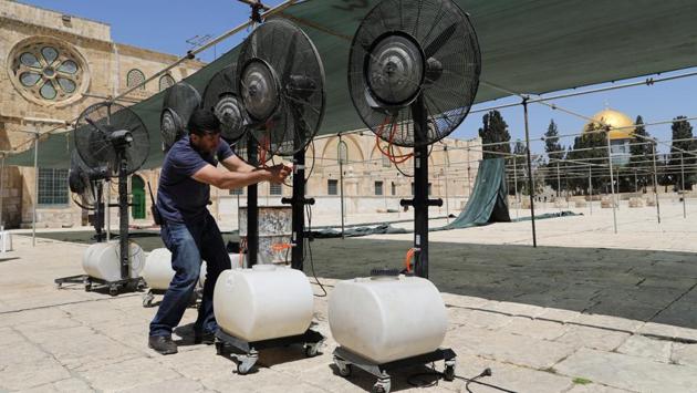 Palestinians employed by the Waqf, the Islamic trust that oversees the mosque and the ancient compound that surrounds it, set up tents for fasting worshippers to take respite from the heat alongside the golden Dome of the Rock. (Ammar Awad/REUTERS)