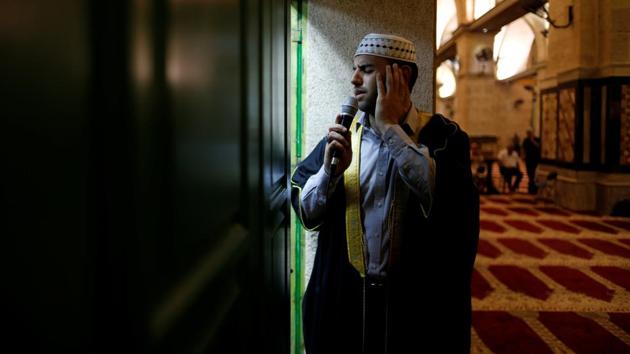 Firas Kazaz, a Palestinian muezzin dressed in traditional clothing calls Muslims to prayer, inside al-Aqsa Mosque. The faithful believe that it was during the month of Ramadan that God revealed the first verses of the Holy Quran, Islam’s sacred text to Mohammed. (Ammar Awad/REUTERS)