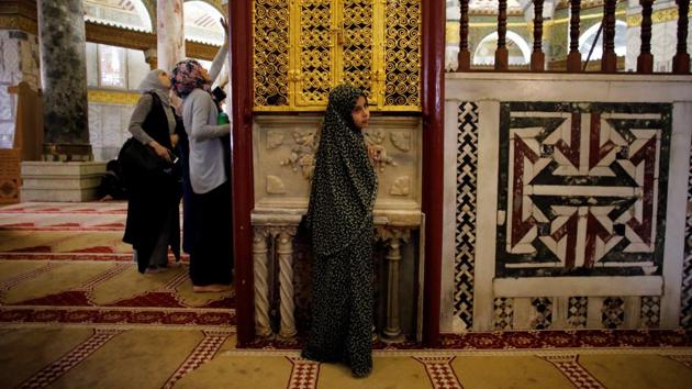 A Palestinian girl places her hand on a marble slab covered with perfume inside the Dome of the Rock. (Ammar Awad/REUTERS)