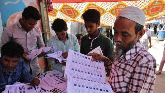 Residents look up their names on the voter list at a polling booth at Bhiwandi in Thane on Wednesday.(Praful Gangurde)