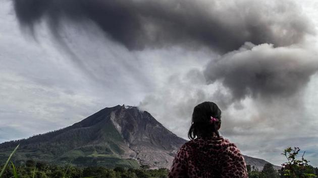 A villager looks on as Mount Sinabung volcano, as seen from Beganding village in Karo. Many homes, school buildings and farms were abandoned between 2010 and 2014 around Mount Sinabung as the government had put up an exclusion zone to save human life. (AFP)