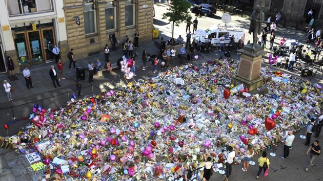 People stand around flower tributes at St Ann's Square, dedicated to the victims of Monday's bombing. (AP) People stand around flower tributes at St Ann's Square, dedicated to the victims of Monday's bombing. (AP)