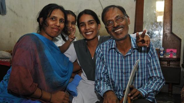 Kewal Chand who works in a football-making firm with his daughter Jyoti Mahey, Jalandhar district PSEB class-10 topper. She lives with her father, mother and a five-year-old sister in a one room house. (HT PHOTO.)