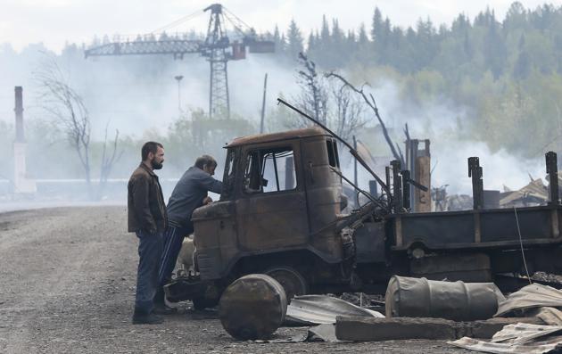 Men inspect a truck burnt during recent wildfire. (Ilya Naymushin / Reuters) Men inspect a truck burnt during recent wildfire. (Ilya Naymushin / Reuters)