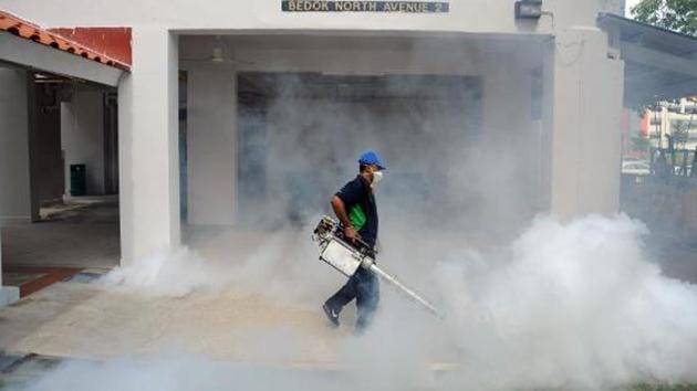 A worker sprays insecticide at a residential area in Singapore. (IANS Photo) A worker sprays insecticide at a residential area in Singapore. (IANS Photo)