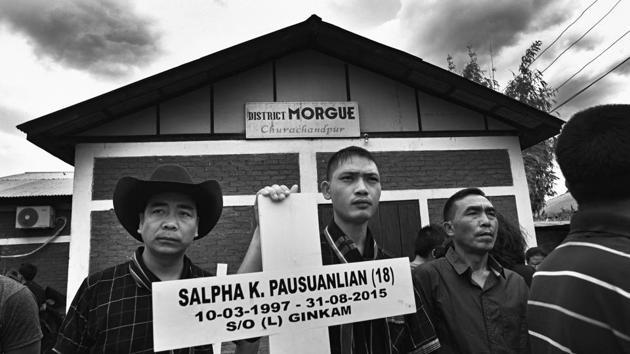 Family members of the victims hold a painted wooden cross outside the morgue at Churachandpur. The Meitei people are the ethnic majority in Manipur and live in the valley, which houses 60 per cent of the state’s population, though it comprises only 10 per cent of the state’s area. The Meitei campaigned for a change in land laws because of the pressure of resources in the valley. (Ravi Choudhary/HT PHOTO)