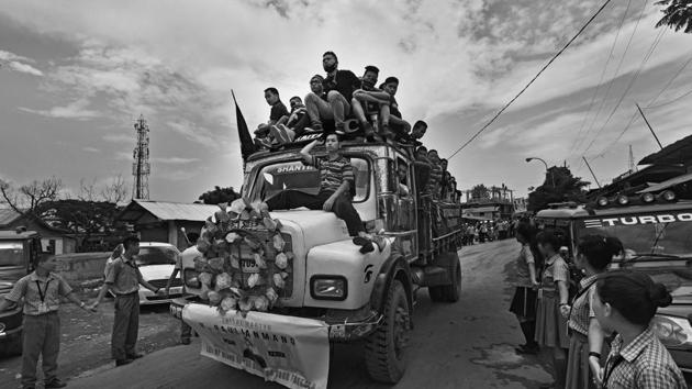 Volunteers travel on a truck with the coffins from the morgue to the Lamka Public Ground as the public pays their last respect to the dead. The initial demands by the tribes included quashing of the bills, justice for the dead and a separate administration for the hill areas. (Ravi Choudhary/HT PHOTO)