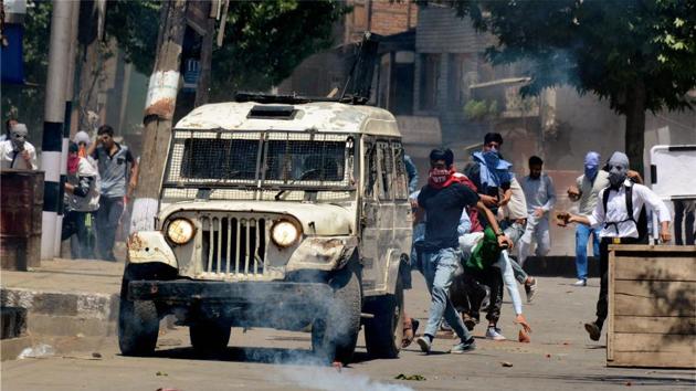 Youth attacks a police vehicle amid tear smoke fired by police during violent clashes which erupt following the killing of Hizbul Mujahideen commander Sabraz Bhat and his associate at Tral during an encounter, in Srinagar on May 27.(PTI Photo)