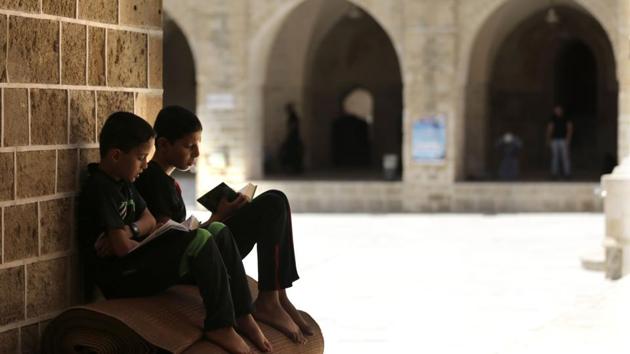 Palestinian children read copies of the Koran, at the al-Omari mosque in Gaza City. (AFP) Palestinian children read copies of the Koran, at the al-Omari mosque in Gaza City. (AFP)