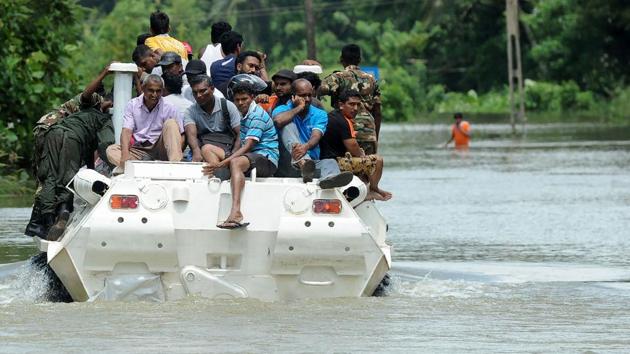 Sri Lankan villagers sit on an army armoured personnel carrier being used in rescue operations during major flooding in Bulathsinhala in Kalutara district on May 27. (AFP Photo) Sri Lankan villagers sit on an army armoured personnel carrier being used in rescue operations during major flooding in Bulathsinhala in Kalutara district on May 27. (AFP Photo)