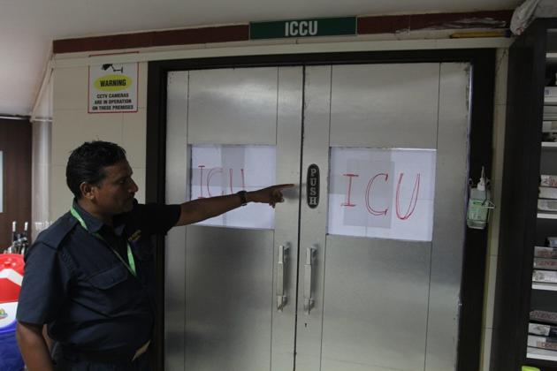 A hospital staff points to the ICU door whose glass panes were shattered.(HT Photo)